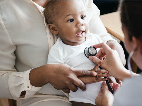 Adorable smiling small child at doctor with stethoscope on his chest