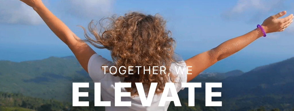 Image of a young girl holding her arms out looking at mountains, text reads "Together, we elevate"