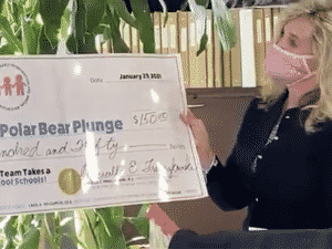 Marcella Franczkowski presents Jim Schumtz with a check for the polar bear plunge