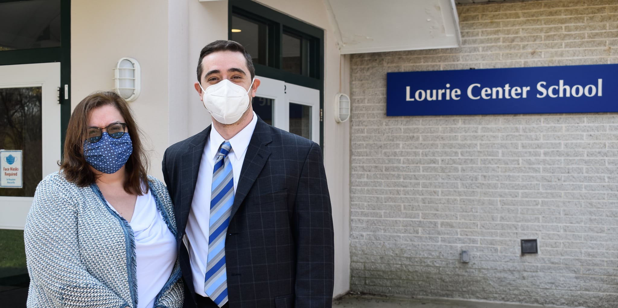Two professionals stand outside the Lourie Center