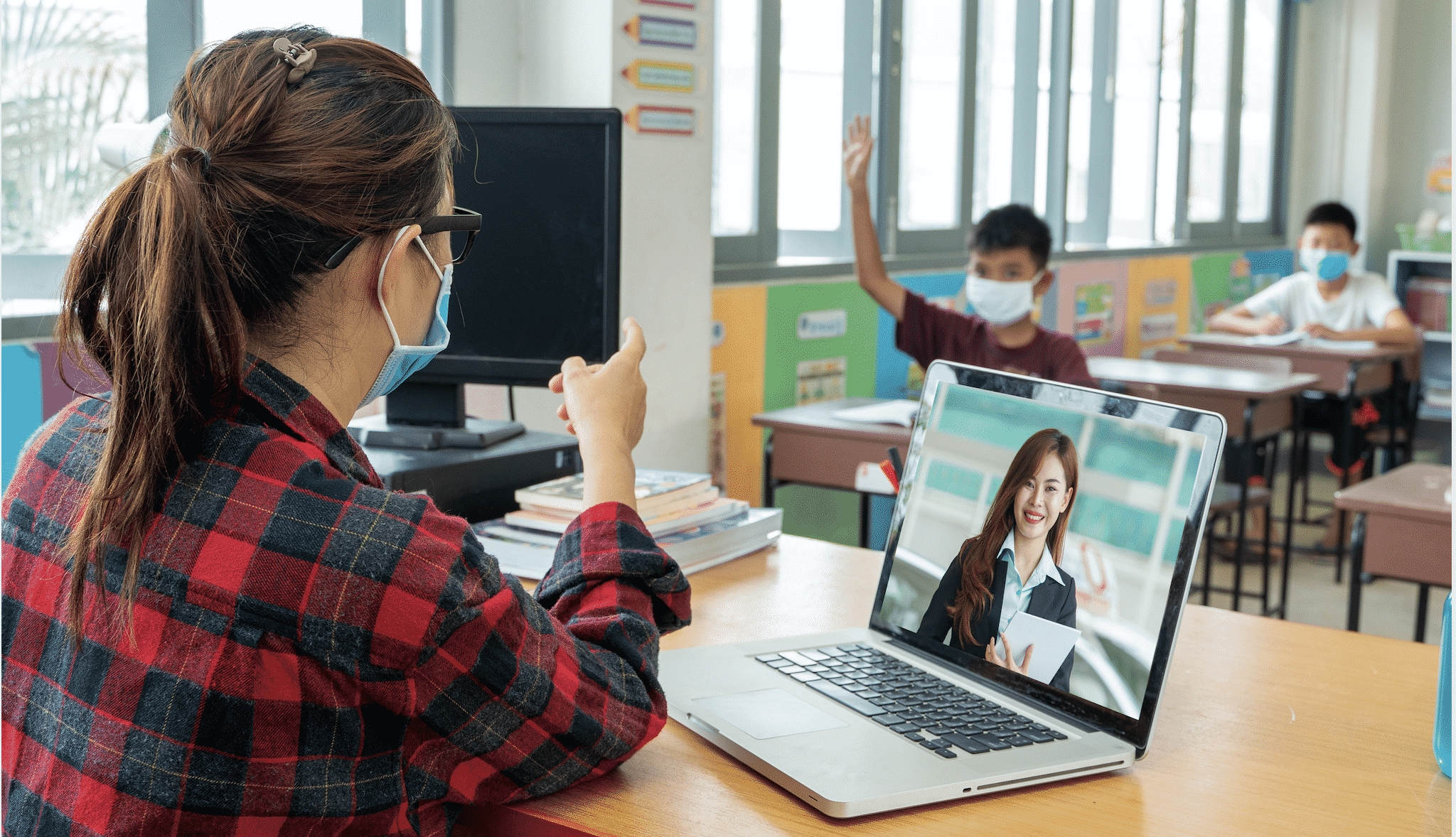 Female teaching both online and remotely in a classroom